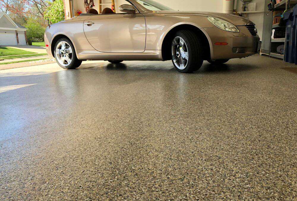 Epoxy garage floor coating with parked cream colored car